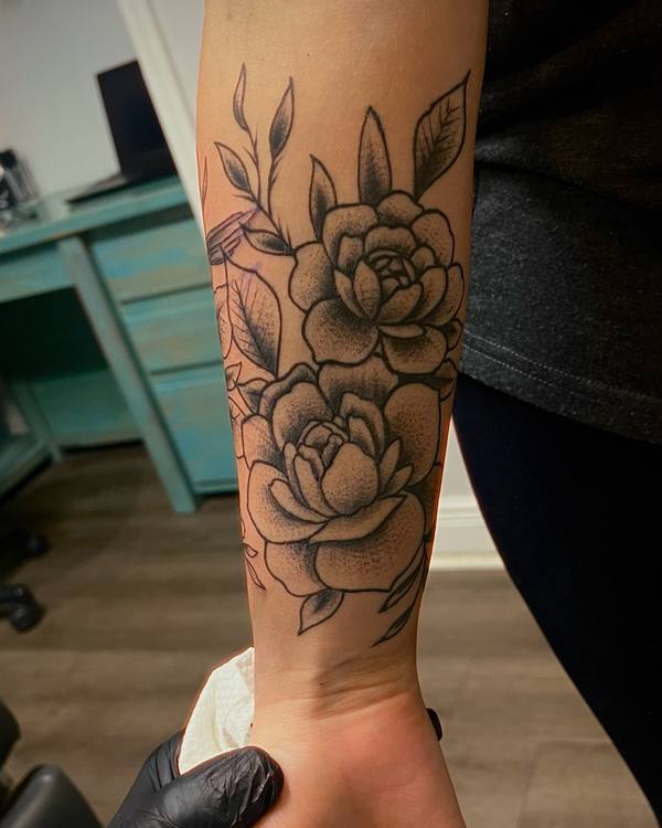 Black and grey roses on a forearm