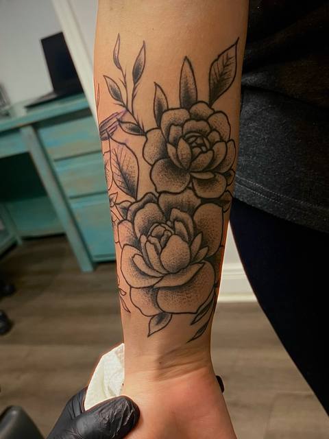 Black and grey roses on a forearm